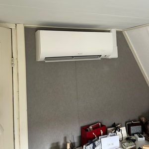 Een wandgemonteerde airco-installatie, ontworpen voor efficiënte koeling en verwarming in een binnenruimte.