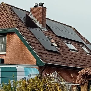 Een woning met een installatie van zonnepanelen op het dak, die is ontworpen om zonne-energie te verzamelen.