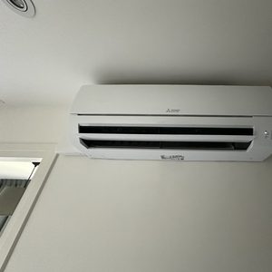 Een wandgemonteerde airconditioner geïnstalleerd voor temperatuurregeling in een binnenruimte.