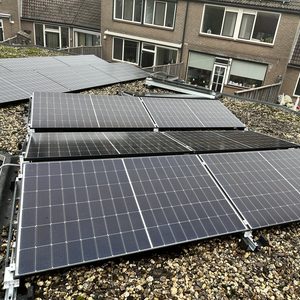 Deze installatie toont een reeks zonnepanelen op een hellend dak, die zijn ontworpen voor het opwekken van zonne-energie.