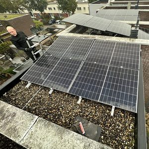 Een installatie van zonnepanelen op een plat dak, met meerdere panelen die efficiënt zonlicht opvangen voor energieproductie.