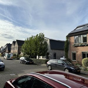 De afbeelding toont een woning met zonnepanelen op het dak, geplaatst voor duurzame energieoplossingen.