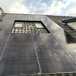 Deze installatie toont zonnepanelen die zijn gemonteerd op een schuine dak. De panelen vangen zonlicht op voor energieopwekking.