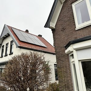 Zonnepanelen zijn geïnstalleerd op het dak van een woning, gericht naar de zon voor optimale energieopbrengst.