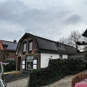 De foto toont een woning met zonnepanelen op het dak, wat wijst op een duurzame energie-installatie.