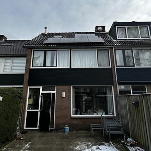 De afbeelding toont een woning met zonnepanelen op het dak, wat duidt op hernieuwbare energieoplossingen voor elektriciteitsopwekking.