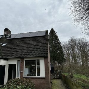 Deze installatie toont zonnepanelen op het dak van een woning, gericht op het benutten van zonne-energie.