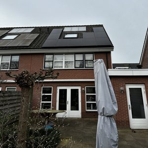 De afbeelding toont een zonnepaneleninstallatie op het dak van een woning, met meerdere panelen zichtbaar, perfect gericht voor zonne-energieopbrengst.