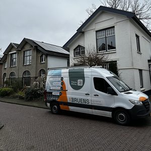 De installatie toont zonnepanelen op het dak van een woning, met een voertuig van een installateur ernaast.