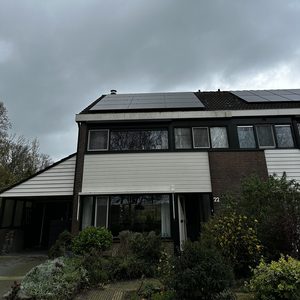 De afbeelding toont een woning met zonnepanelen op het dak, geïntegreerd in een moderne architectuur.
