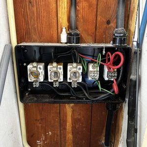 Een meterkast met aansluitingen voor elektra, inclusief diverse kabels voor stroomdistributie.