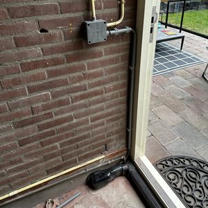 Installatie van een meterkast met wandcontactdozen en leidingen, gericht op elektrische voorzieningen in de ruimte.