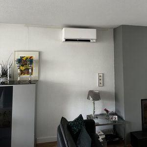 De installatie toont een wandairco-plafondunit, geplaatst in een moderne woonomgeving.