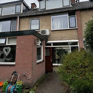 Een airconditioning unit is zichtbaar aan de buitenzijde van het huis, geschikt voor het koelen van binnenruimtes.