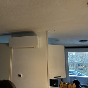 De afbeelding toont een wand-aangedreven airconditioningseenheid, strategisch geplaatst om efficiëntie in koeling en verwarming te verbeteren in een woonruimte.