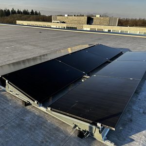 Een installatie van zonnepanelen op een plat dak, optimaal gepositioneerd voor zonlicht. De panelen zijn geïntegreerd in een stevig montagesysteem.