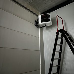 Een wandairconditioningseenheid is geïnstalleerd in een hoek van de ruimte, klaar voor gebruik.