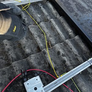 De foto toont een zonnepaneleninstallatie op een dak, met zichtbare aansluitingen en bekabeling voor het systeem.