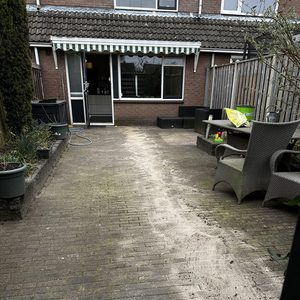 De foto toont een ruimte buiten met een duidelijk zichtbare meterkast in de nabijheid van de woning.