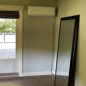 Een wandgemonteerde airconditioner is geïnstalleerd in een kamer, klaar voor gebruik.
