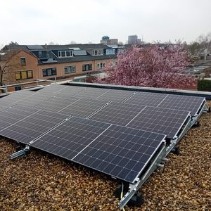 Deze installatie toont een set zonnepanelen op een dak, geïnstalleerd op een grindbed.