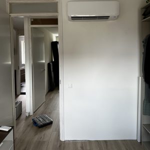 Een wandmodel airconditioningunit is geïnstalleerd in een kamer, klaar voor gebruik.