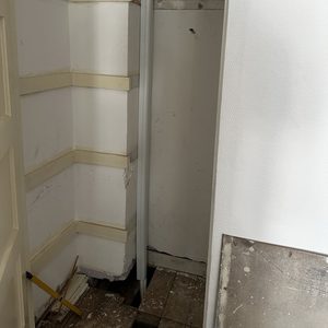 De foto toont een ruimte met voorbereidingen voor de installatie van een airconditioningseenheid, inclusief leidingen en wandstructuren.