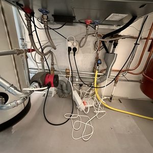 Deze installatie toont een warmtepomp met leidingen en aansluitingen voor warmteverdeling en energielevering.
