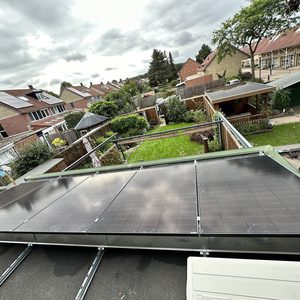 Een installatie van zonnepanelen op een schuine dak met meerdere panelen zichtbaar.