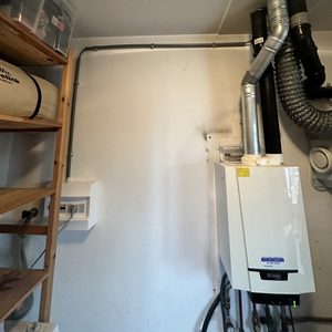 De foto toont een deel van een installatie met een omvormer die typisch is voor zonnepanelen.