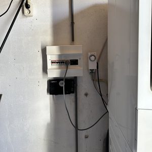 De afbeelding toont een meterkast met aansluitingen voor elektrische systemen en mogelijk zonnepanelen, geconfigureerd voor energiebeheer.