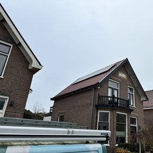 De foto toont zonnepanelen op het dak van een woning, geïnstalleerd voor hernieuwbare energieoplossingen.