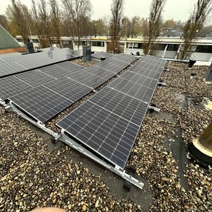 Een installatie van zonnepanelen op een dak, met meerdere panelen die netjes zijn gerangschikt op een grindbediening.