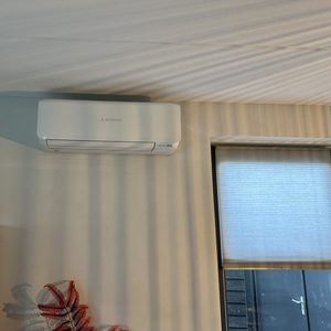 Een gemonteerde airconditioningseenheid aan de muur, ontworpen voor efficiënte koeling van de ruimte.