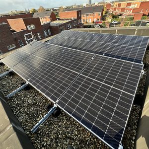 Deze installatie toont een reeks zonnepanelen op een plat dak, netjes geïnstalleerd met een steenslagbed.