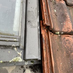 De installatie toont een integraal zonnepanelensysteem dat bovenop dakpannen geplaatst is, met zichtbare details van de aansluiting.