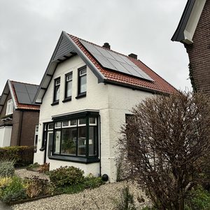 De foto toont een woning met zonnepanelen op het dak, ideaal voor zonne-energieproductie.