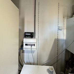 Het beeld toont een meterkast met de installatiecomponenten van een zonnepanelenproject.