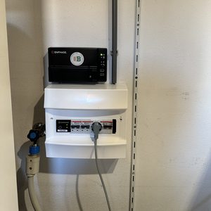 De afbeelding toont een omvormer en meterkast die behoren tot een zonnepanelen installatie. Deze componenten zijn essentieel voor het omzetten van zonne-energie naar gebruiksklare stroom.