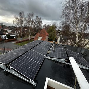 De afbeelding toont een installatie van zonnepanelen op een dak met meerdere panelen, gericht op het optimaliseren van zonne-energie. Het is duidelijk zichtbaar dat de panelen professioneel zijn geïnstalleerd.