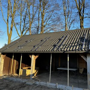 Installatie van zonnepanelen op een hellend dak, met zichtbare bevestigingssystemen en bedrading.