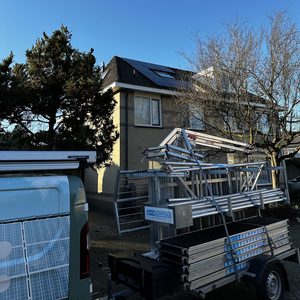 Zonnepanelen zijn geïnstalleerd op een dak, met een heldere blauwe lucht op de achtergrond.
