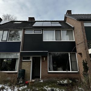 De foto toont een woning met zonnepanelen op het dak, wat aangeeft dat deze energietransitie is uitgevoerd.