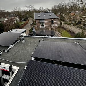 Installatie van zonnepanelen op een dak, zichtbaar met zonnepanelen en een deel van de omgeving.