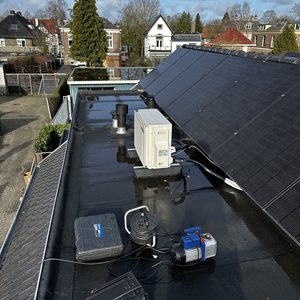 Een luchtgeconditioneerde installatie op het dak, naast zonnepanelen en diverse technische apparatuur.