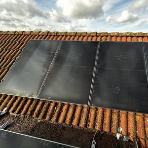 Een montage van zonnepanelen op een schuin dak, zichtbaar met de omliggende dakpannen.