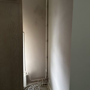 De foto toont de leidingen en bedrading die mogelijk gerelateerd zijn aan een zonnepaneleninstallatie, maar toont niet de panelen zelf.