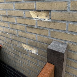 De foto toont een muur met voorbereidingen voor de installatie van een laadpaal. Er zijn bevestigingspunten zichtbaar in de muur.