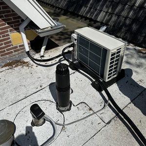 Een airconditioninginstallatie op het dak met leidingen en een buitenunit, klaar voor gebruik.