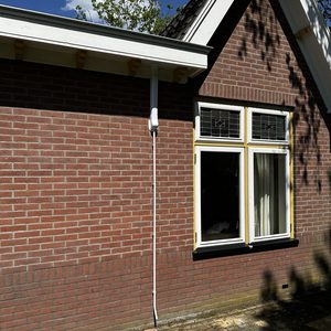 Een buitenunit van een airconditioning systeem geïnstalleerd aan de gevel van een huis.